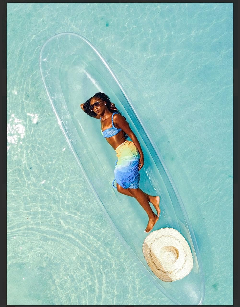 Guest lying in a clear kayak over turquoise water